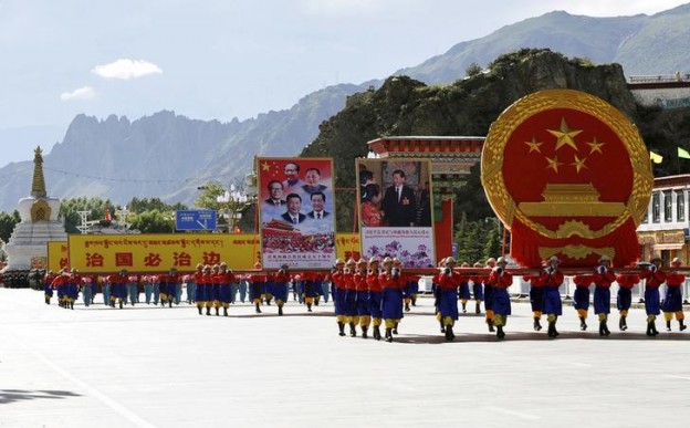 Performers carry a giant Chinese national emblem and pictures of Chinese government leaders during the celebration event at the Potala Palace marking the 50th anniversary of the founding of the Tibet Autonomous Region, in Lhasa