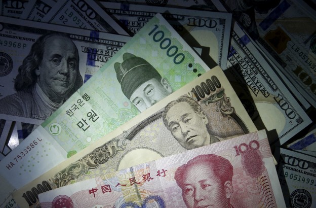 South Korean won, Chinese yuan and Japanese yen notes are seen on U.S. 100 dollar notes in this picture illustration  December 15, 2015.    REUTERS/Kim Hong-Ji//Illustration/File photo - RTX2FUK7