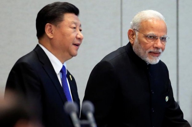 China's President Xi Jinping and India's Prime Minister Narendra Modi arrive for a signing ceremony during Shanghai Cooperation Organization (SCO) summit in Qingdao, Shandong Province, China June 10, 2018. REUTERS/Aly Song - RC1B14B27D40