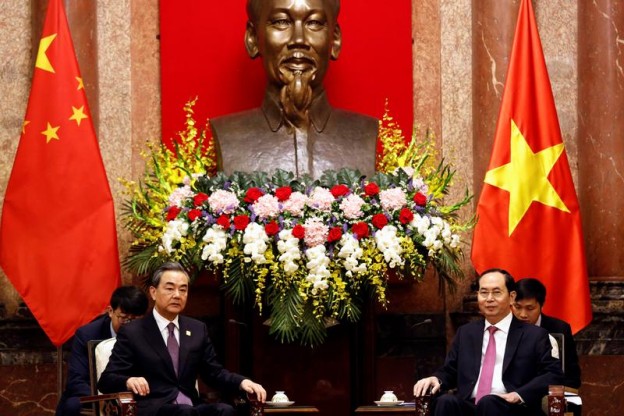 China's State Councilor and Foreign Minister Wang Yi and Vietnam's President Tran Dai Quang talk under a statue of the late Vietnamese revolutionary leader Ho Chi Minh at the Presidential Palace in Hanoi, Vietnam April 1, 2018. REUTERS/Kham - RC1F290C7D80