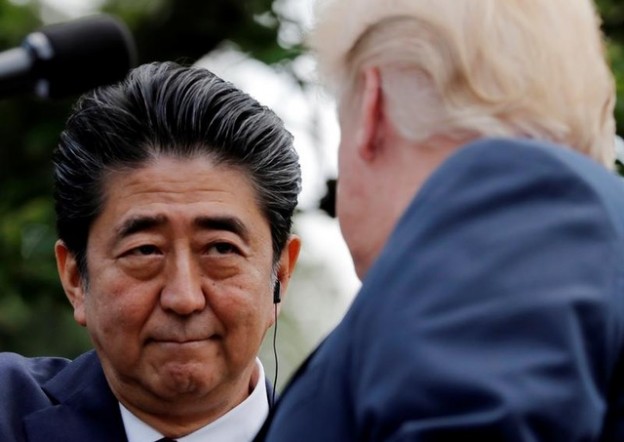 Japan's Prime Minister Shinzo Abe looks into U.S. President Donald Trump's eyes as they shake hands during a joint news conference in the Rose Garden of the White House in Washington, U.S., June 7, 2018. REUTERS/Carlos Barria - RC13DE766DC0