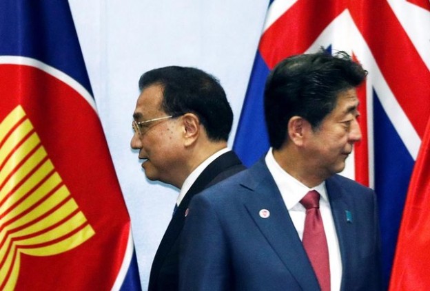China's Premier Li Keqiang passes Japan's Prime Minister Shinzo Abe as they gather for a group photo with ASEAN leaders at the Regional Comprehensive Economic Partnership (RCEP) meeting in Singapore November 14, 2018. REUTERS/Edgar Su - RC19B87CBAD0