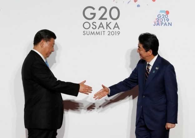 Chinese President Xi Jinping is welcomed by Japanese Prime Minister Shinzo Abe upon his arrival for a welcome and family photo session at G20 leaders summit in Osaka, Japan, June 28, 2019.   REUTERS/Kim Kyung-Hoon/Pool - RC1621D81DA0