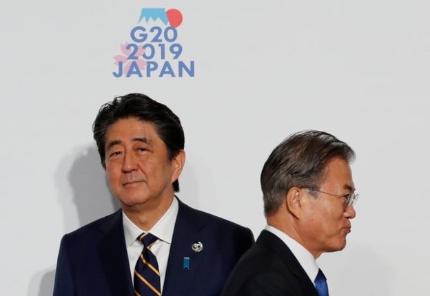 South Korean President Moon Jae-In is welcomed by Japanese Prime Minister Shinzo Abe upon his arrival for a welcome and family photo session at G20 leaders summit in Osaka, Japan, June 28, 2019. REUTERS/Kim Kyung-Hoon/Pool - RC1FCA9B2AB0