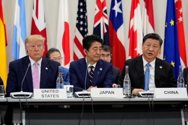 Japan's Prime Minister Shinzo Abe is flanked by U.S. President Donald Trump and China's President Xi Jinping during a meeting at the G20 leaders summit in Osaka, Japan, June 28, 2019.  REUTERS/Kevin Lamarque - RC1D49F184E0