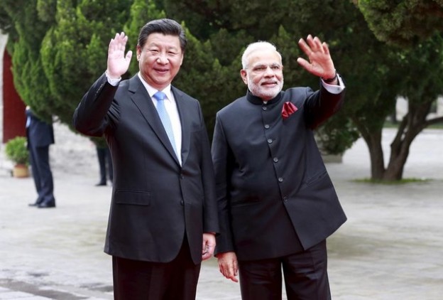 Chinese President Xi Jinping (L) and Indian Prime Minister Narendra Modi wave as they visit Dacien Buddhist Temple in Xian, Shaanxi province, China, May 14, 2015. REUTERS/China Daily CHINA OUT. NO COMMERCIAL OR EDITORIAL SALES IN CHINA - GF10000094720